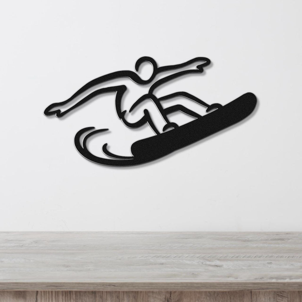 Black metal snowboarder wall art with a dynamic silhouette and motion lines, mounted on a white wall above a wooden counter.
