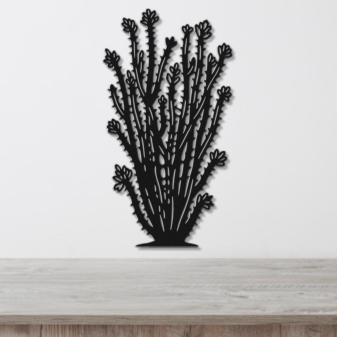 Black metal ocotillo wall art with detailed branch and flower cutouts, mounted on a white wall above a light wood counter.