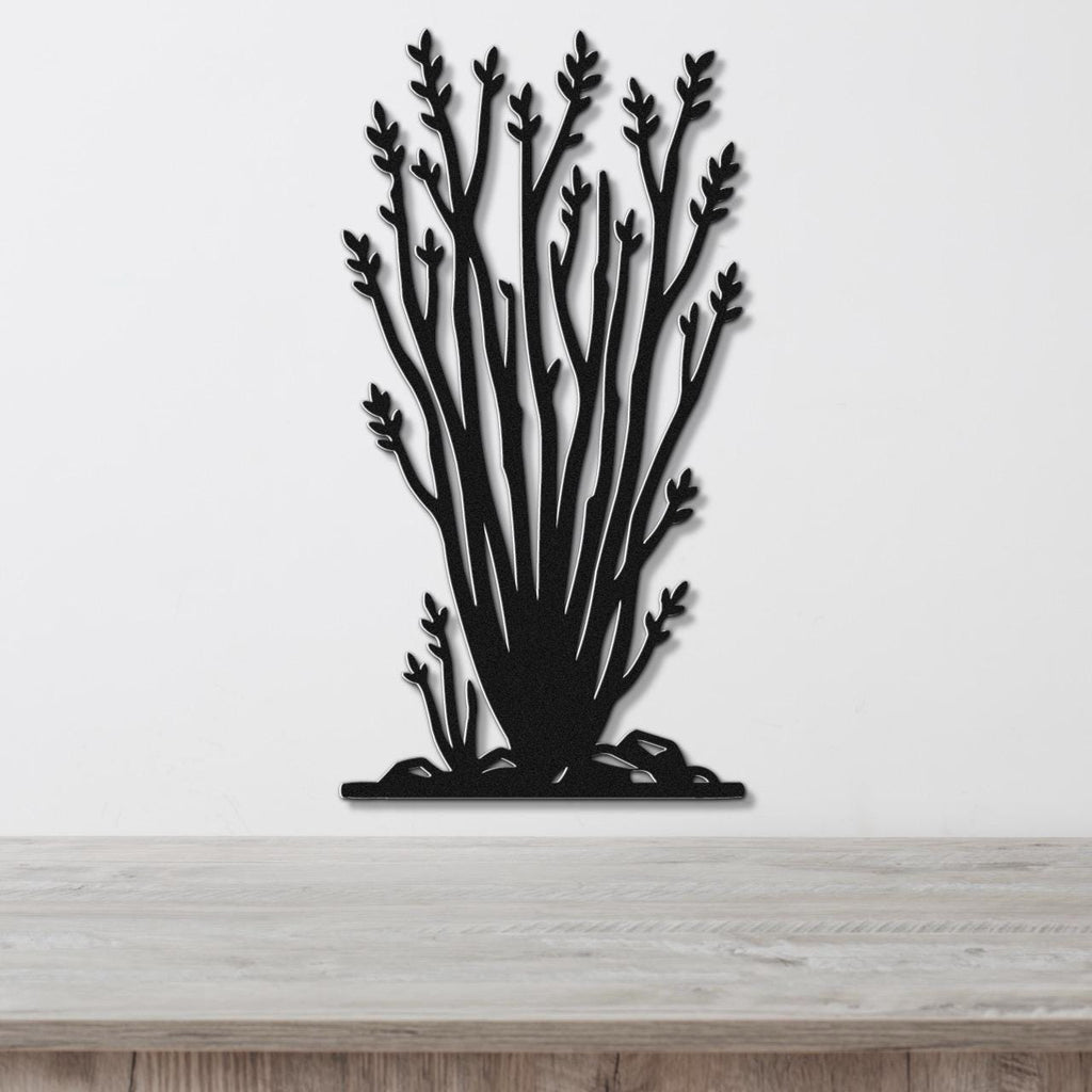 Black metal wall art cutout of an ocotillo plant with branching stems and leaf clusters, mounted on a white wall above a light wood surface.
