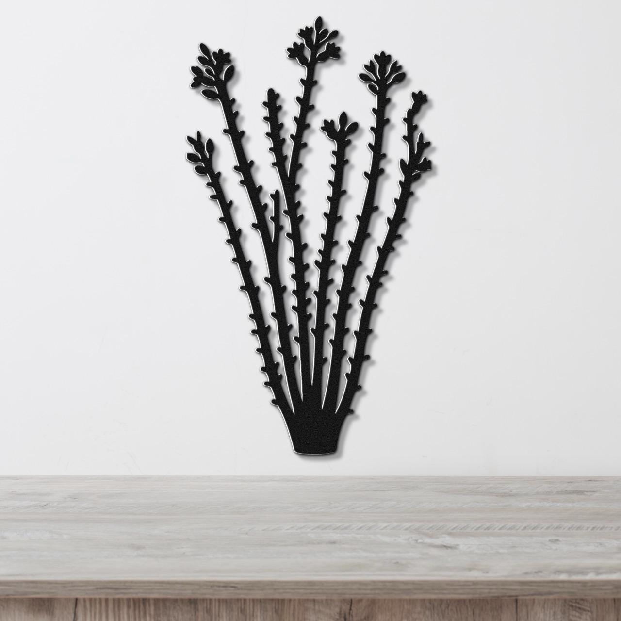 Black metal ocotillo wall art with spiny branch cutouts, mounted on a white wall above a light wood counter.
