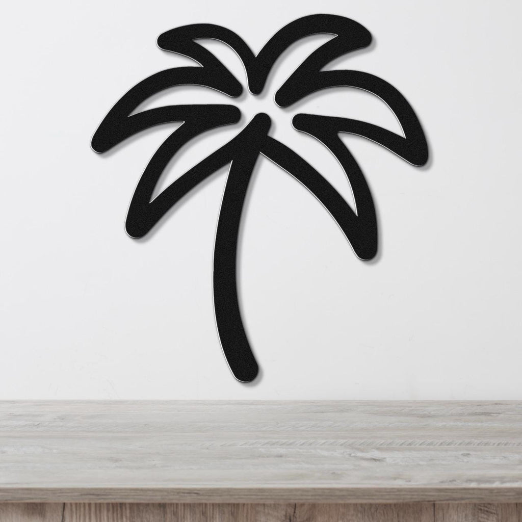 Black metal palm tree wall art with a cutout silhouette design, mounted on a white wall above a light wood surface.