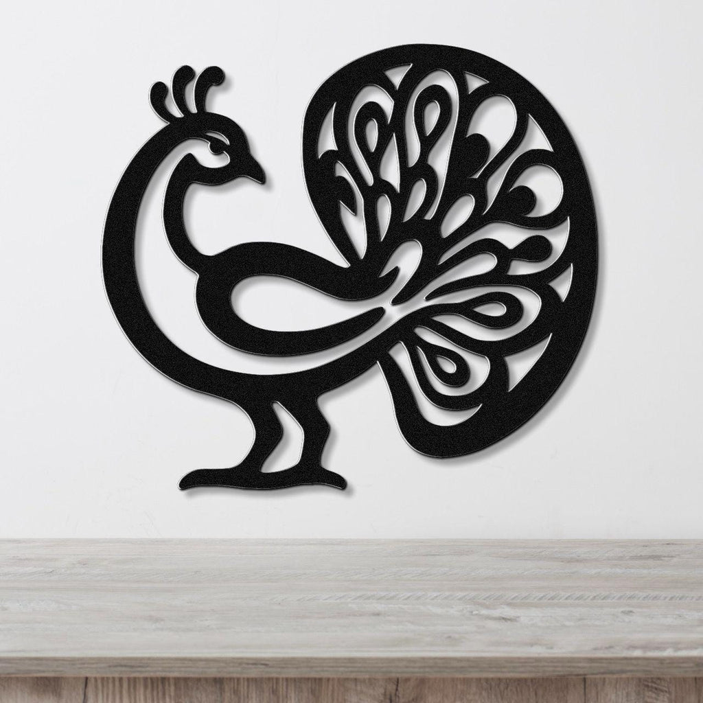 Black metal peacock wall art with intricate feather cutouts, mounted on a white wall above a wooden surface.