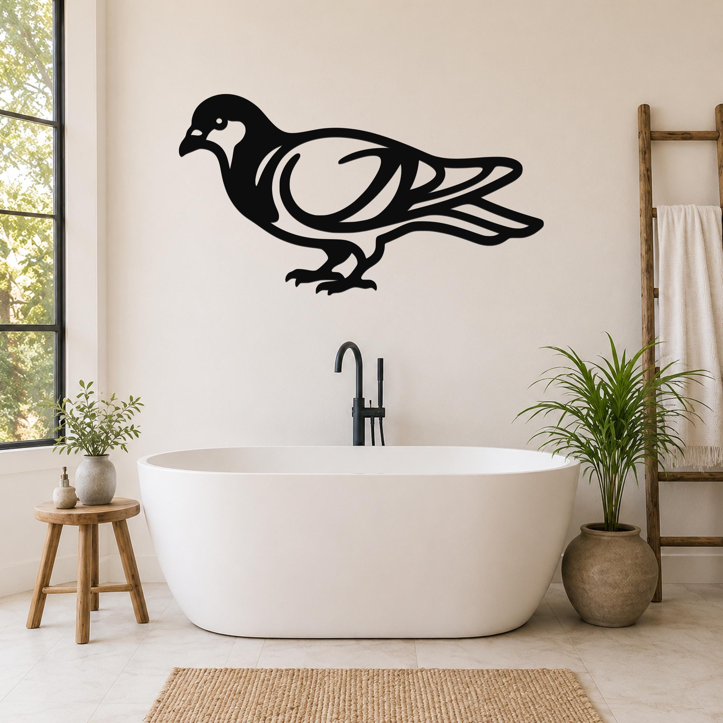 Black metal pigeon wall art with internal cutout details, mounted on a bathroom wall above a freestanding tub.