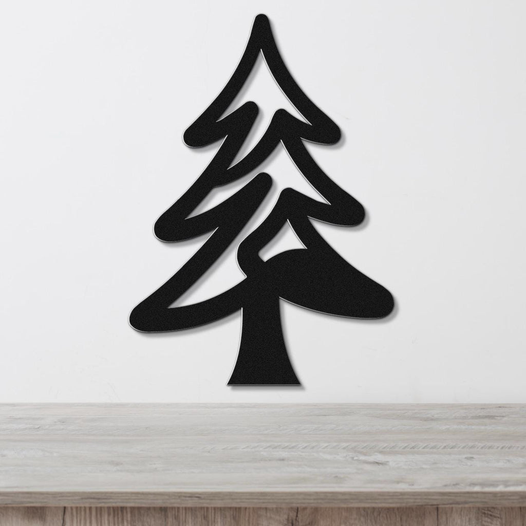 Black metal pine tree wall art with layered branch cutouts, mounted on a white wall above a light wood counter.
