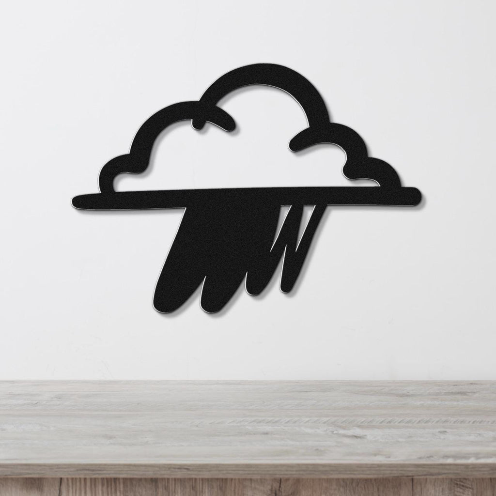 Black metal wall art in the shape of a rain cloud with raindrop cutouts, mounted on a white wall above a wooden surface.
