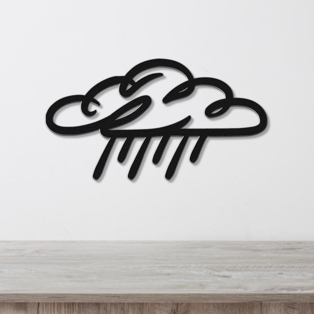 Black metal wall art in a cloud and raindrop silhouette design, mounted on a white wall above a light wood surface.