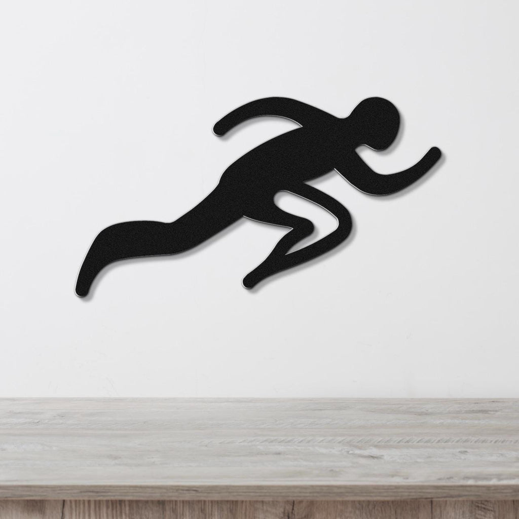 Black metal runner wall art with motion-line cutouts, mounted on a white wall above a light wood counter.