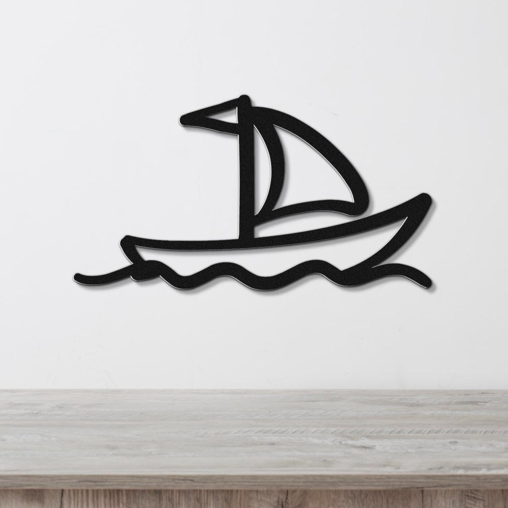 Black metal sailboat wall art with wave cutouts, mounted on a white wall above a light wood surface.