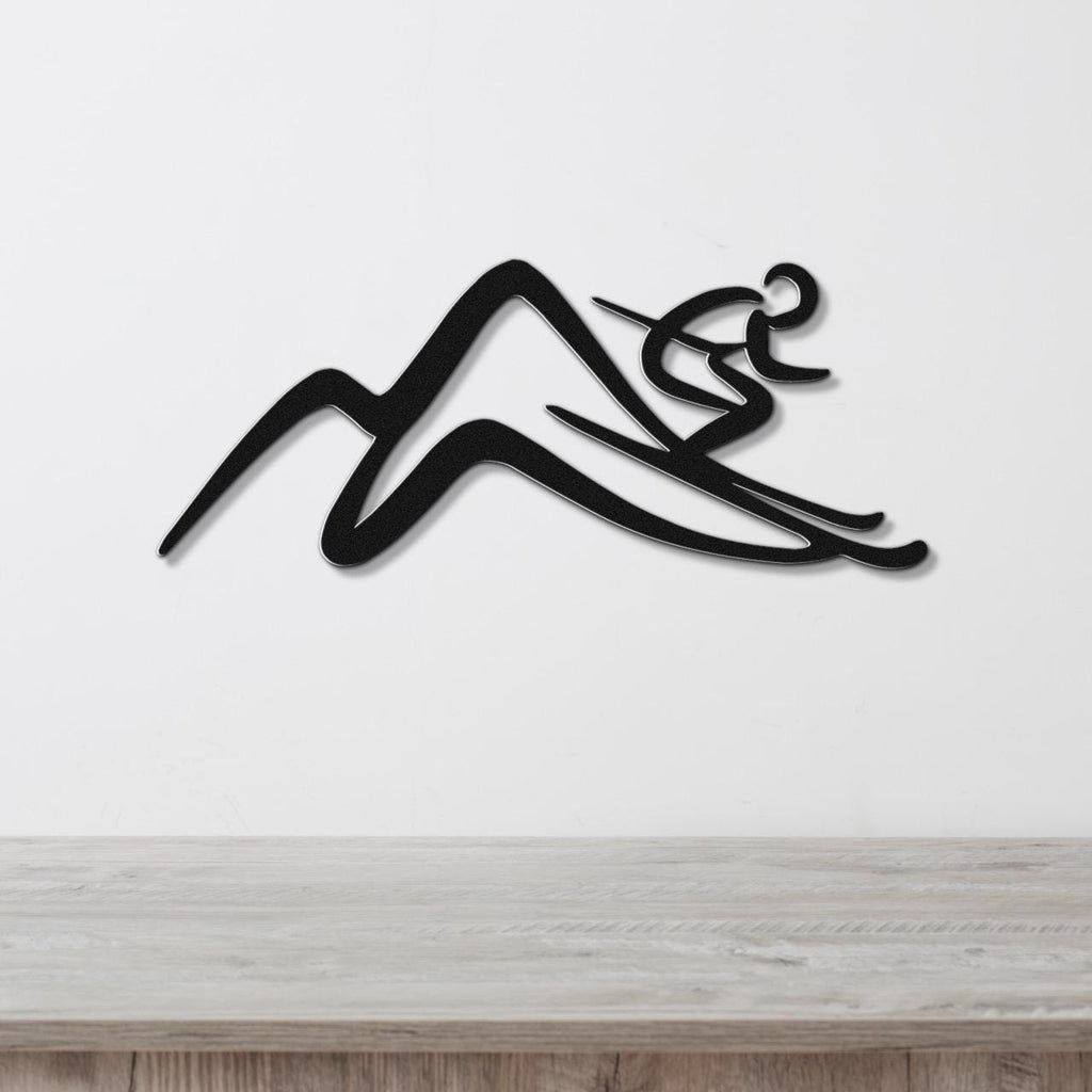 Black metal wall art featuring a skier silhouette gliding over mountain peaks, mounted on a white wall above a light wood counter.