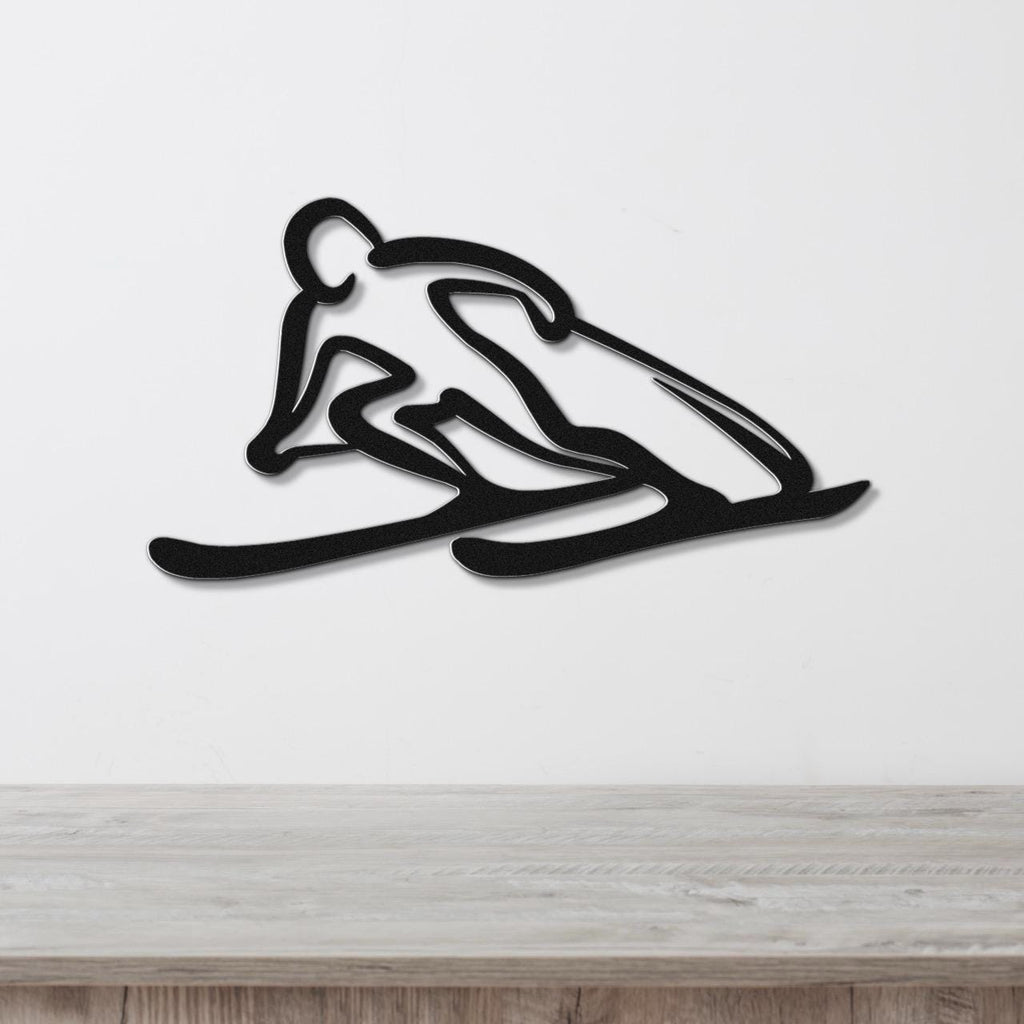 Black metal wall art of a skier silhouette with motion-line cutouts, mounted on a white wall above a light wood counter.