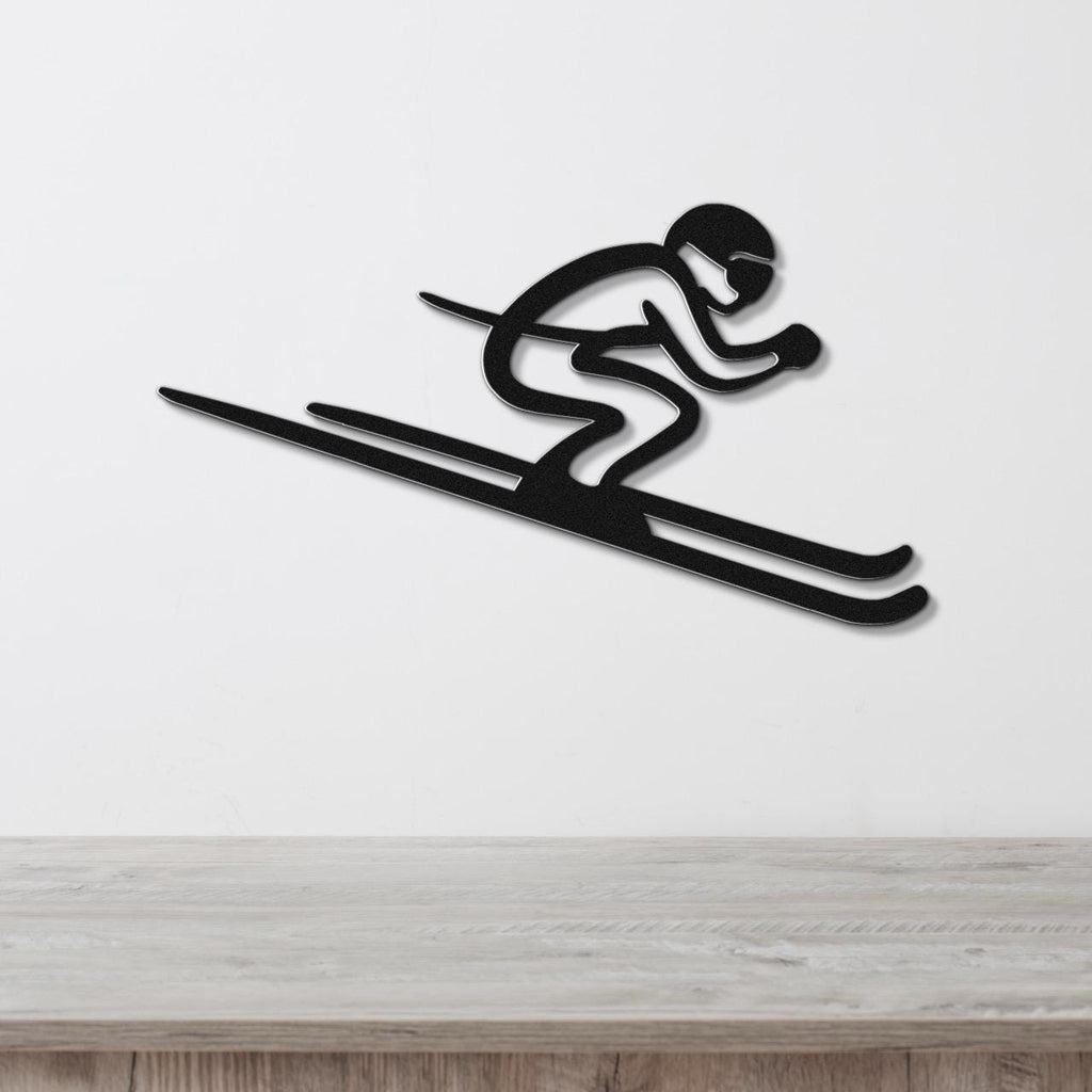Black metal wall art of a skier silhouette with motion lines, mounted on a white wall above a wooden surface.