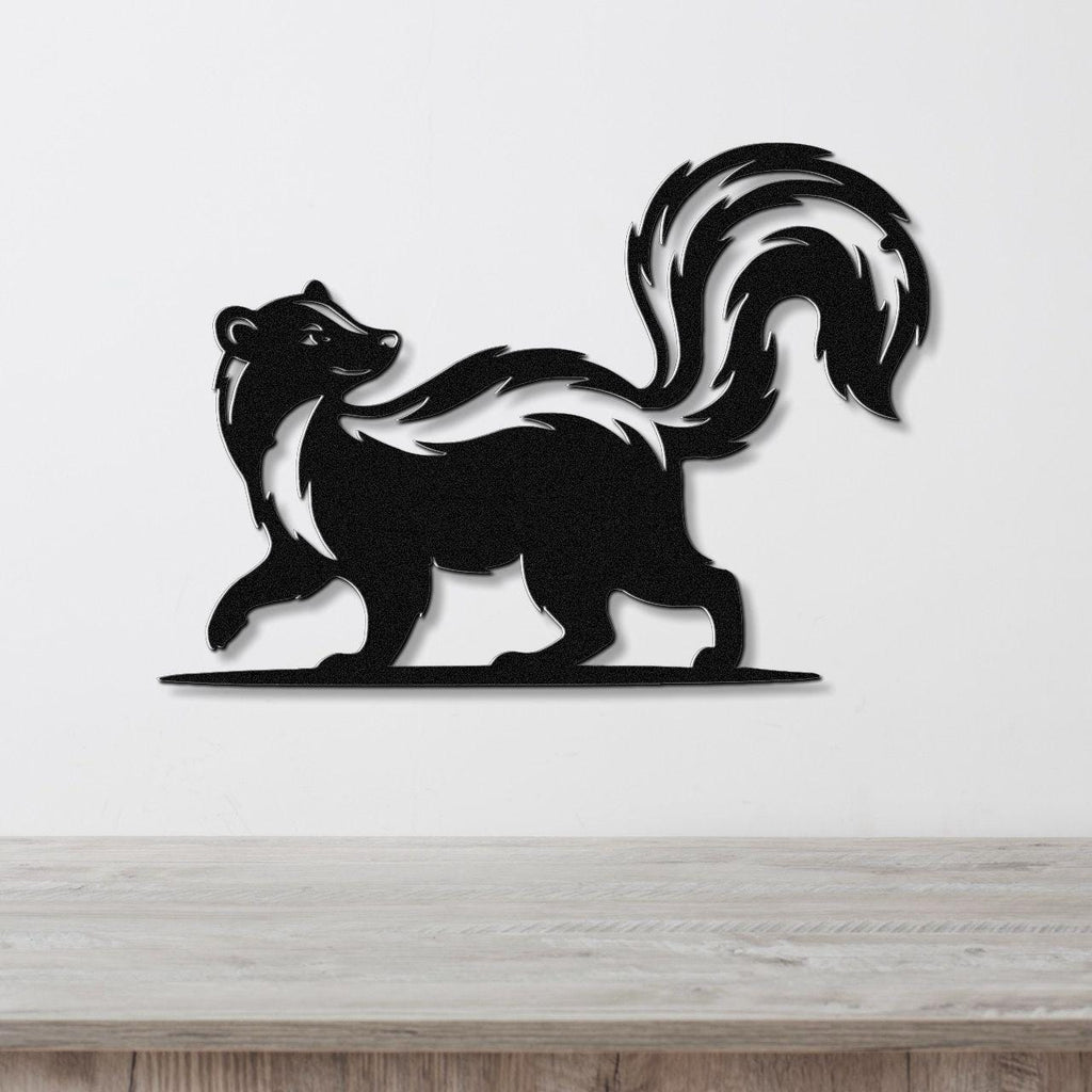 Black metal skunk wall art silhouette with a raised tail and white stripe, mounted on a white wall above a wooden surface.