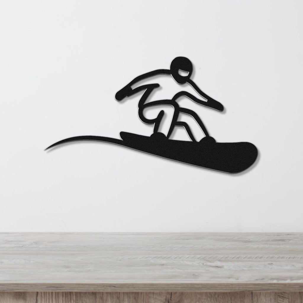 Black metal snowboarder wall art with a bold silhouette and motion-line cutout, mounted on a white wall above a light wood counter.