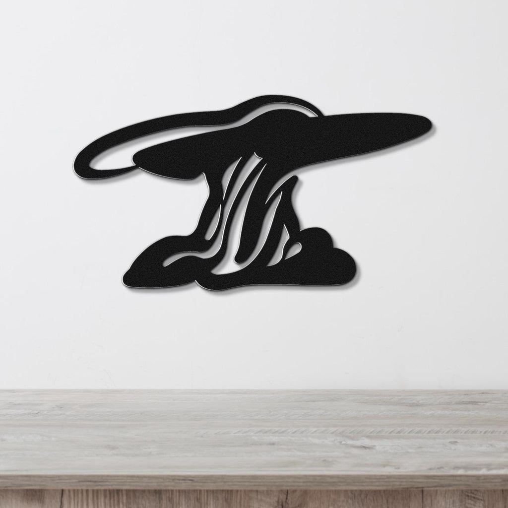 Black metal wall art silhouette of storm clouds with internal cutout lines, mounted on a white wall above a light wood surface.