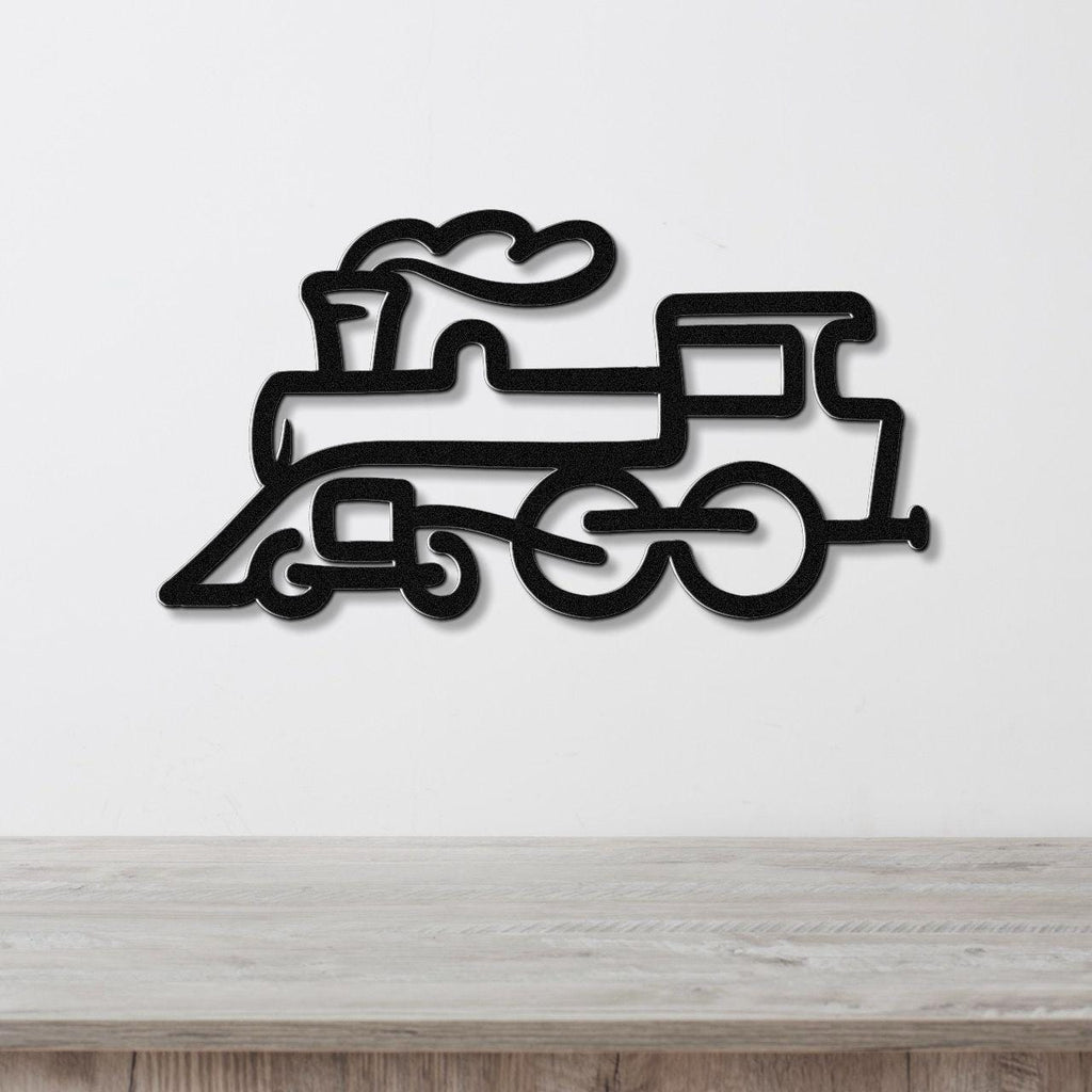 Black metal train wall art with a silhouette design of a steam locomotive, mounted on a white wall above a wooden surface.