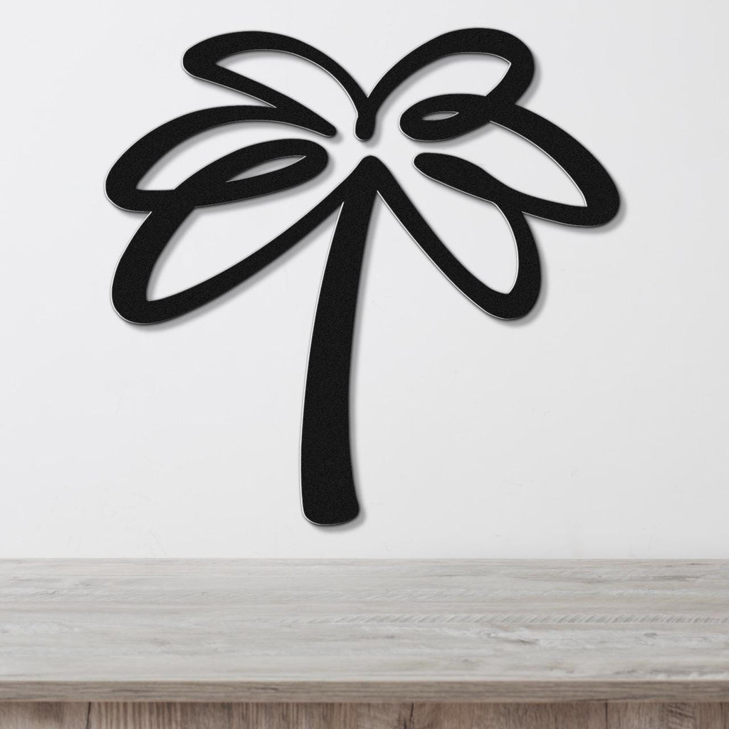 Black metal palm tree wall art with leaf cutouts, mounted on a white wall above a light wood surface.
