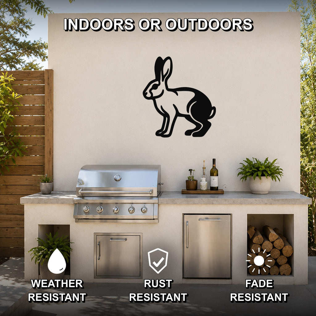 Black metal jackrabbit wall art silhouette mounted on an outdoor patio wall above a stainless steel grill and counter.