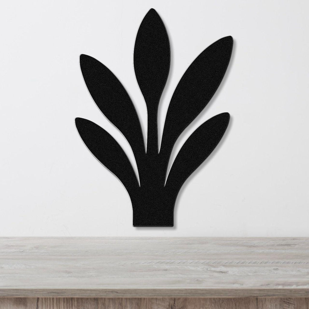Black metal wall art in a snake plant silhouette with five leaf cutouts, mounted on a white wall above a light wood surface.