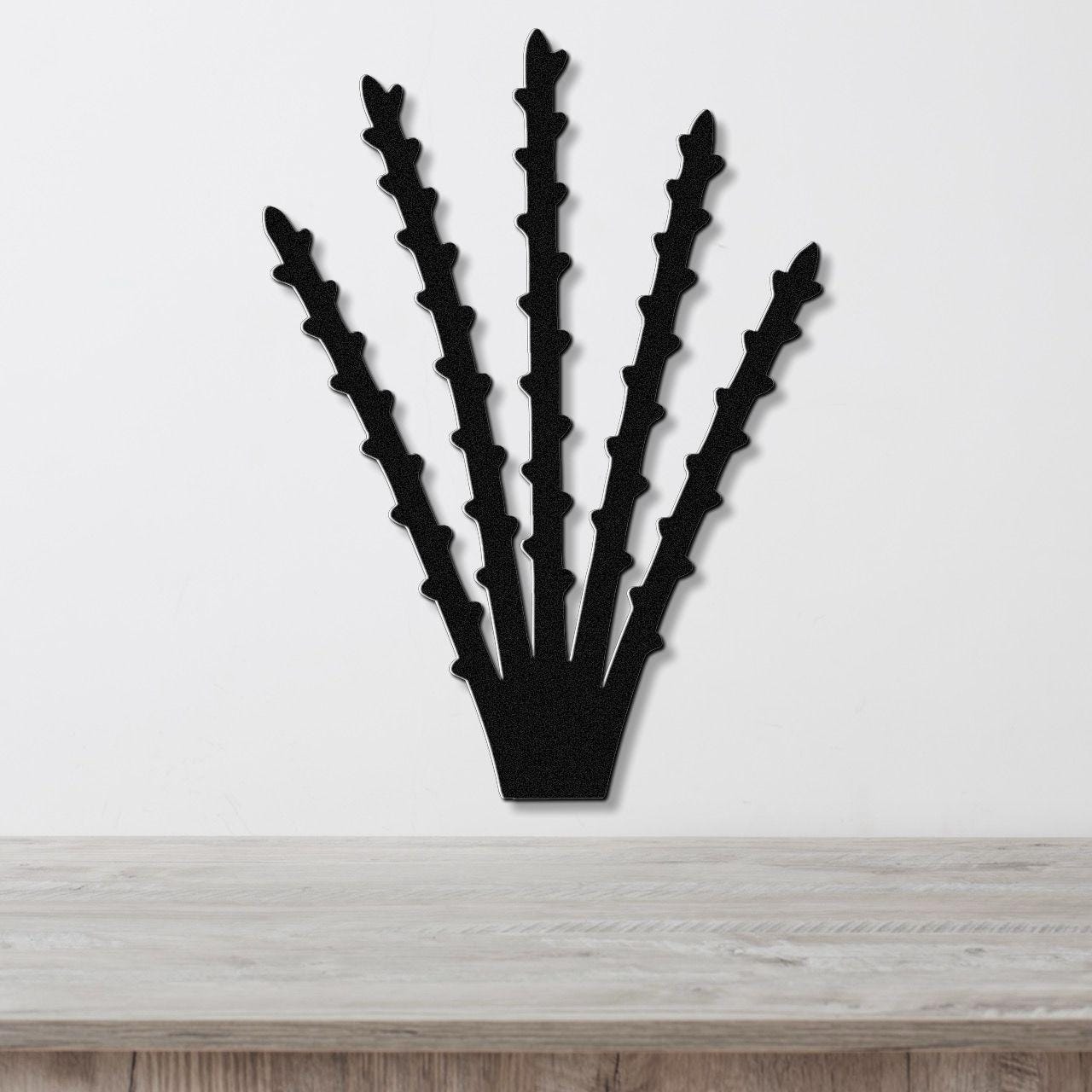 Black metal ocotillo wall art with spiky branch cutouts, mounted on a white wall above a light wood counter.