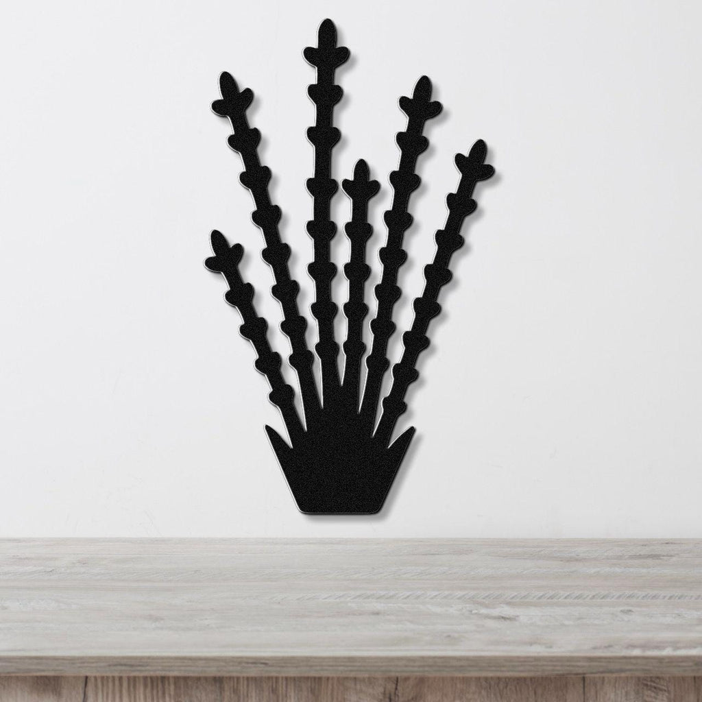 Black metal wall art cutout of an ocotillo plant with multiple spiky stems, mounted on a white wall above a light wood surface.