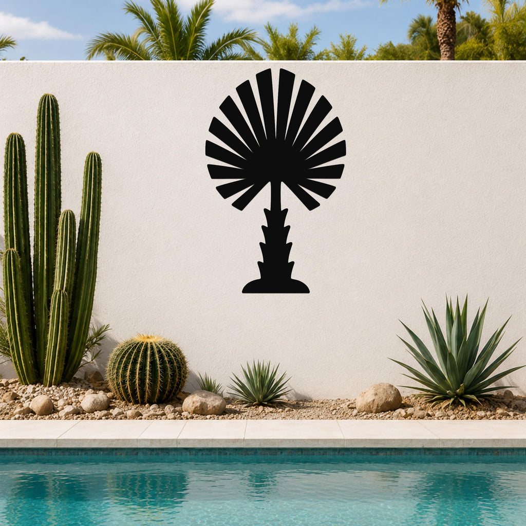 Black metal palm tree wall art with fan-shaped fronds, mounted on a white outdoor wall above a pool and desert plants.