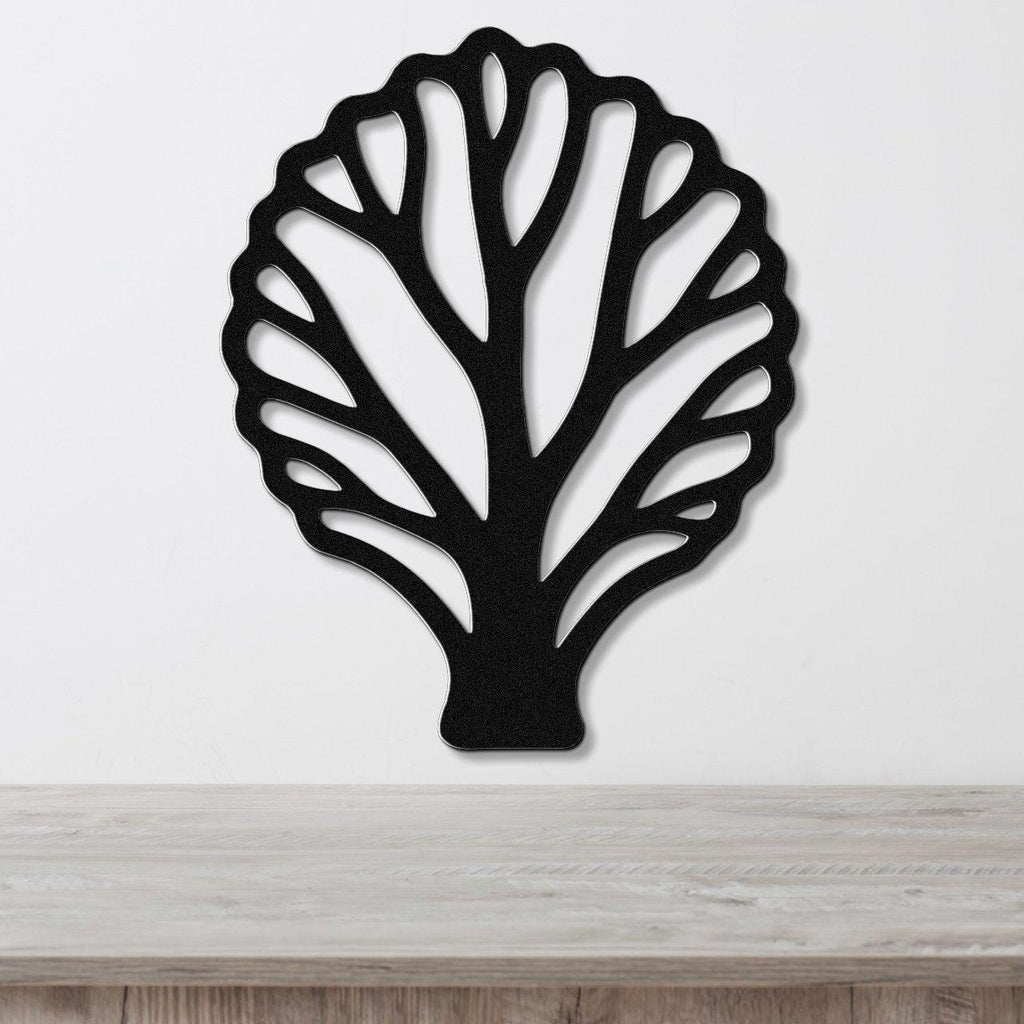 Black metal wall art in a fan coral silhouette with intricate cutout branches, mounted on a white wall above a light wood surface.
