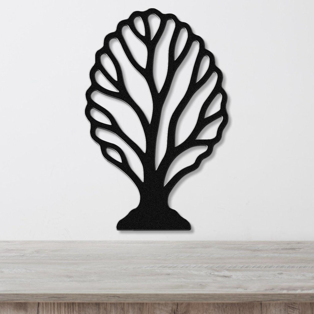 Black metal wall art in a fan coral silhouette with intricate branch cutouts, mounted on a white wall above a light wood surface.