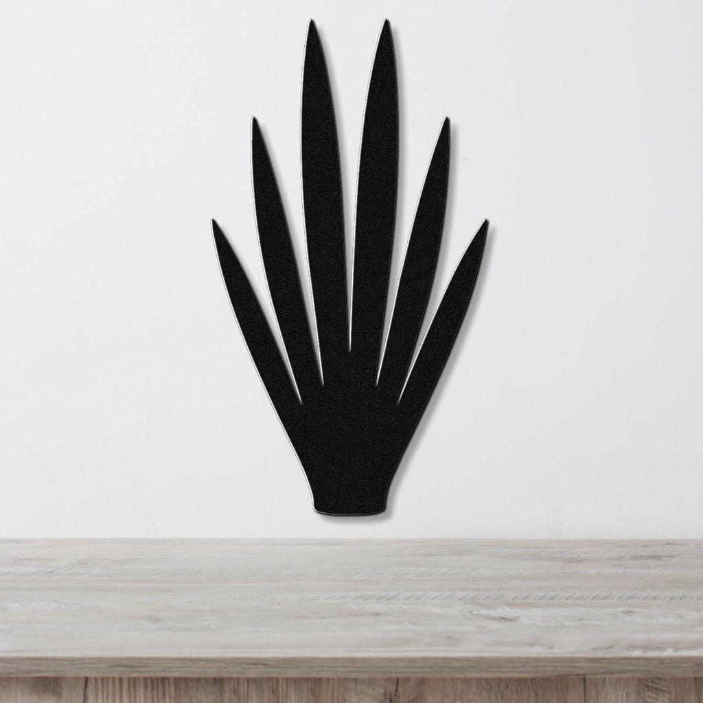 Black metal yucca wall art with pointed leaf cutouts, mounted on a white wall above a light wood countertop.