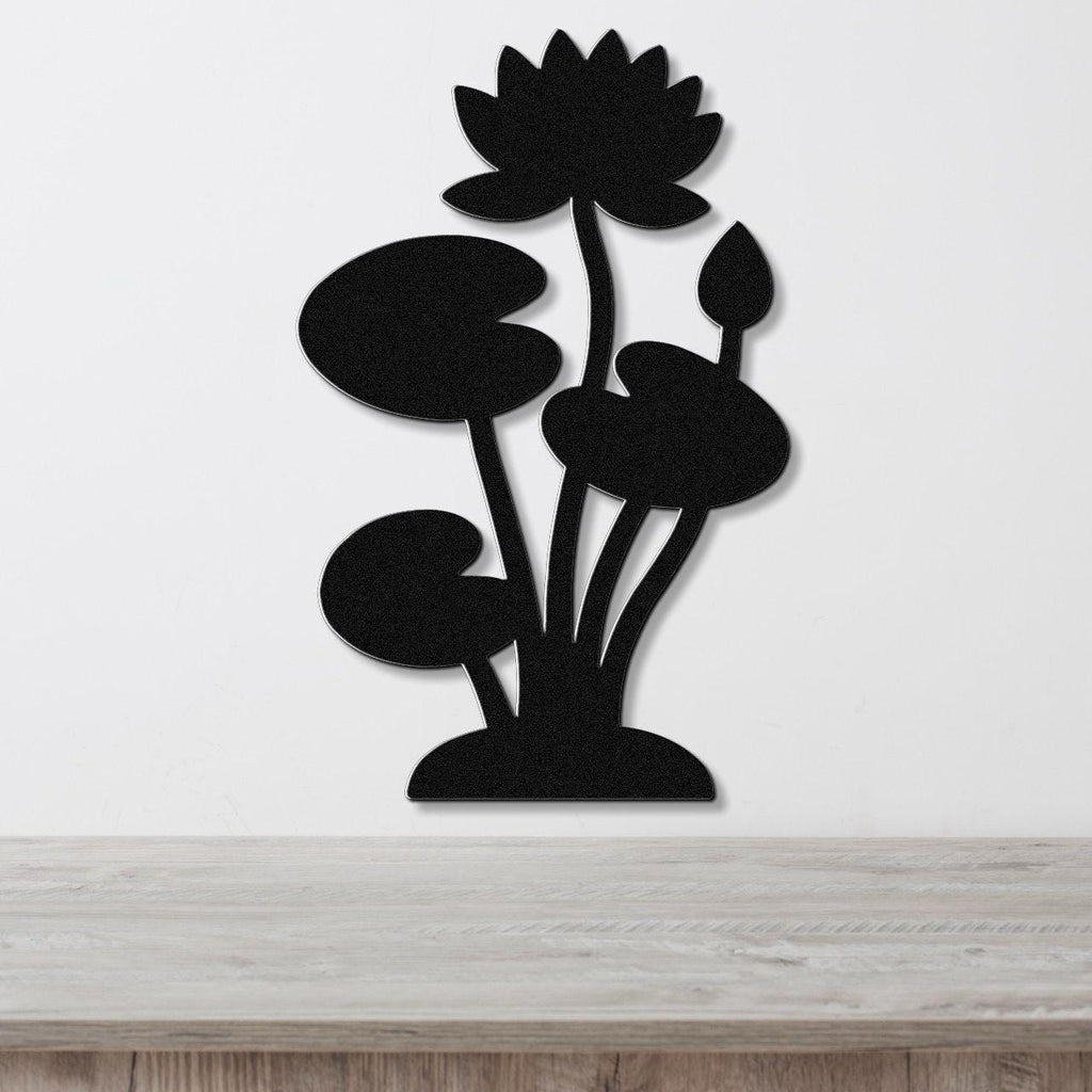 Black metal wall art silhouette of a lotus water lily with multiple leaves and a blooming flower, mounted on a white wall above a light wood surface.