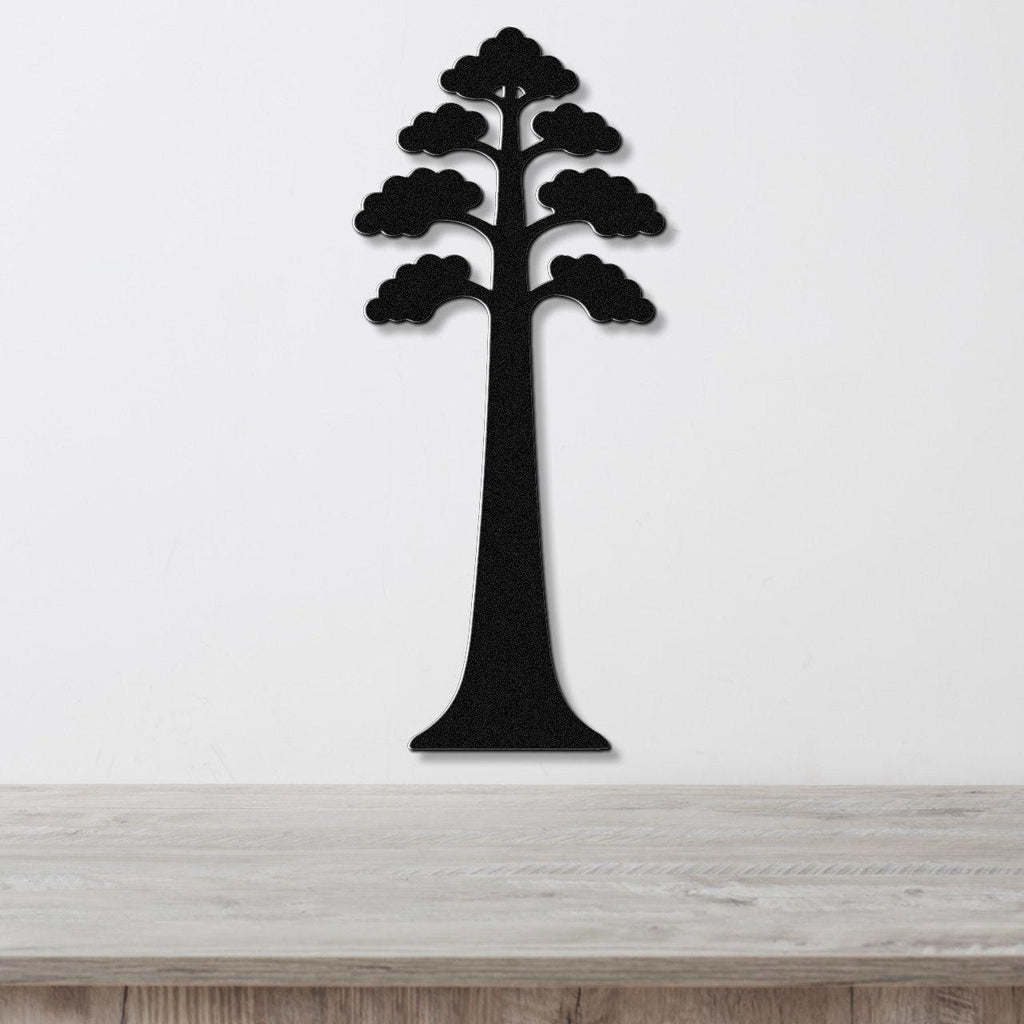 Black metal wall art in the silhouette of a sequoia tree with layered canopy cutouts, mounted on a white wall above a light wood surface.