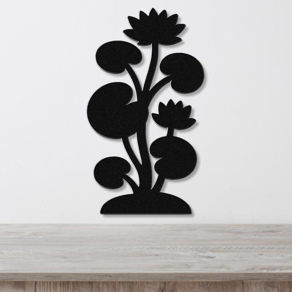 Black metal wall art cutout of a lotus plant with two flowers and lily pads, mounted on a white wall above a wooden surface.