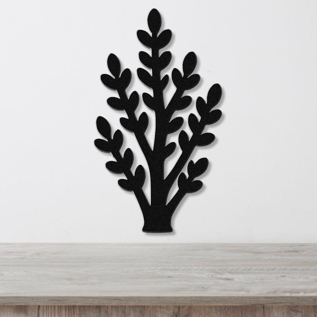 Black metal wall art in a jade plant silhouette with layered leaf cutouts, mounted on a white wall above a light wood surface.