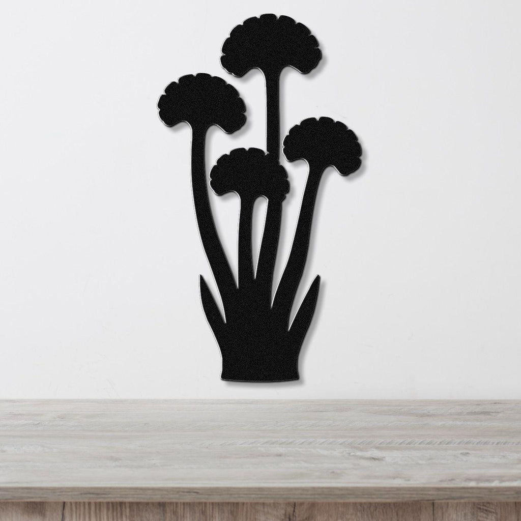Black metal wall art featuring a ginkgo leaf silhouette with multiple stems and leaf cutouts, mounted on a white wall above a light wood surface.