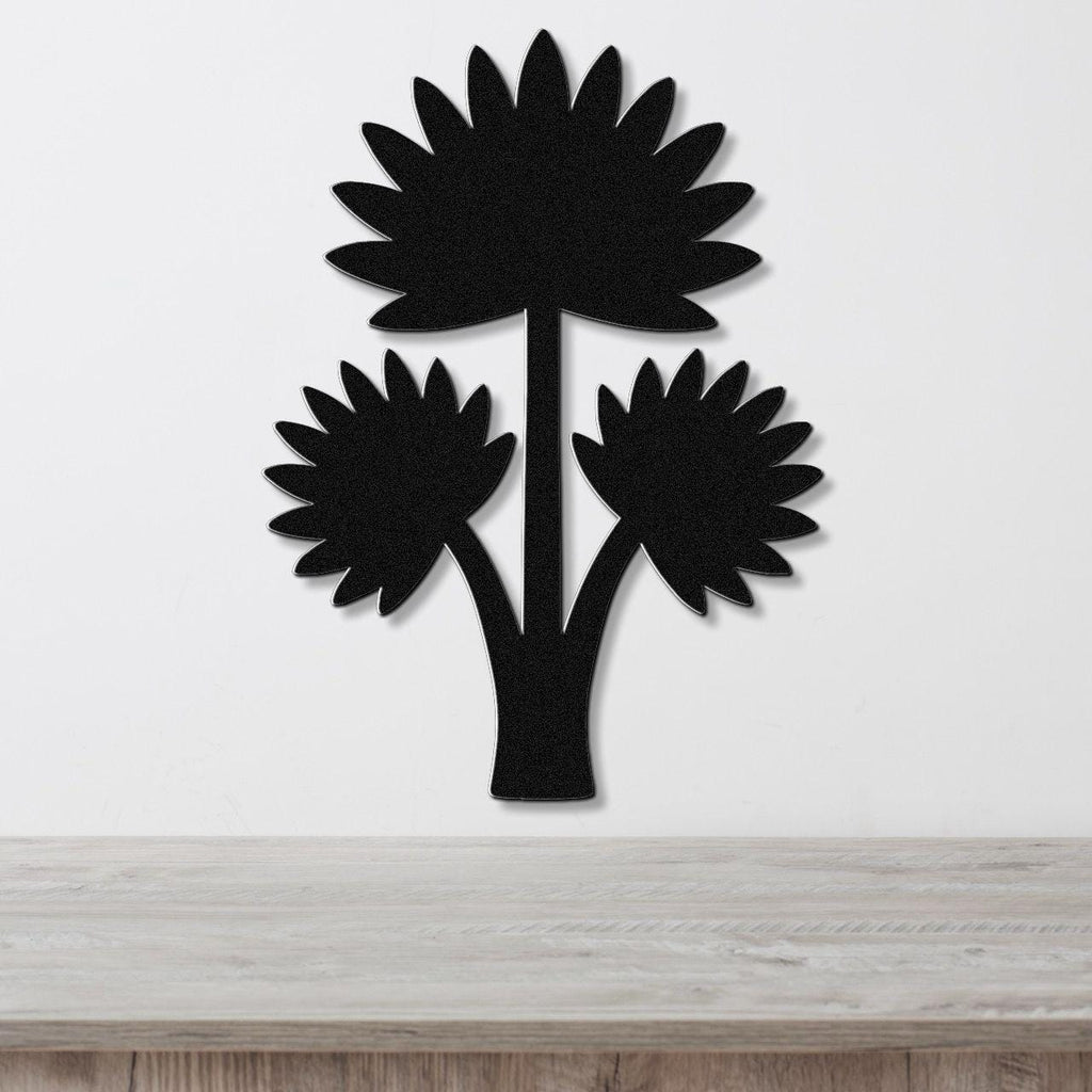 Black metal wall art in a fan palm tree silhouette with three leafy fronds, mounted on a white wall above a light wood surface.