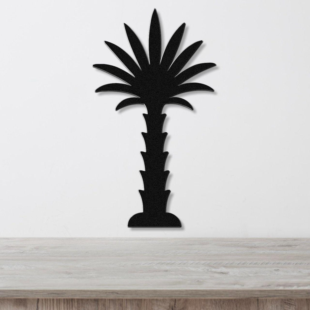 Black metal palm tree wall art with a silhouette cutout design, mounted on a white wall above a light wood countertop.