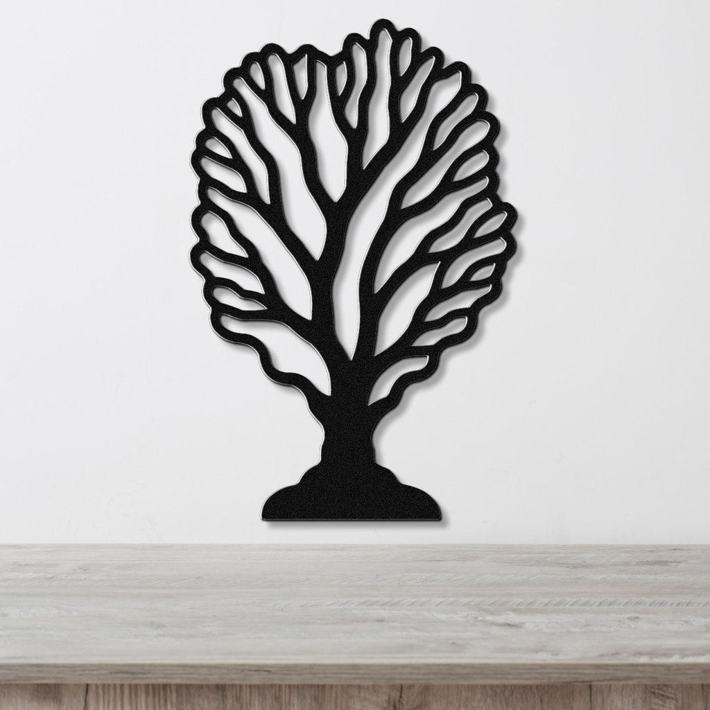 Black metal wall art cutout of a fan coral design, mounted on a white wall above a light wood surface.