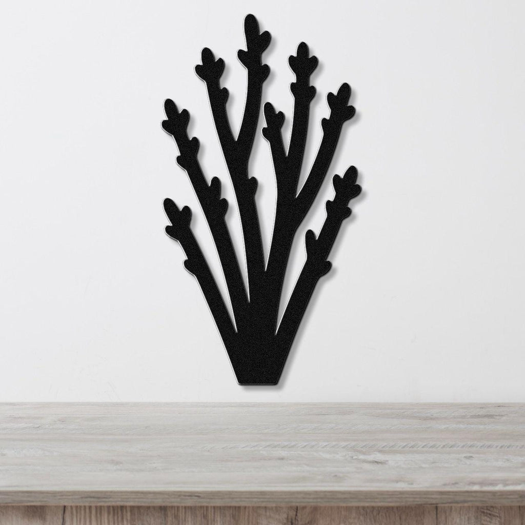 Black metal wall art in a silhouette of desert branches with multiple upward-reaching limbs, mounted on a white wall above a light wood surface.