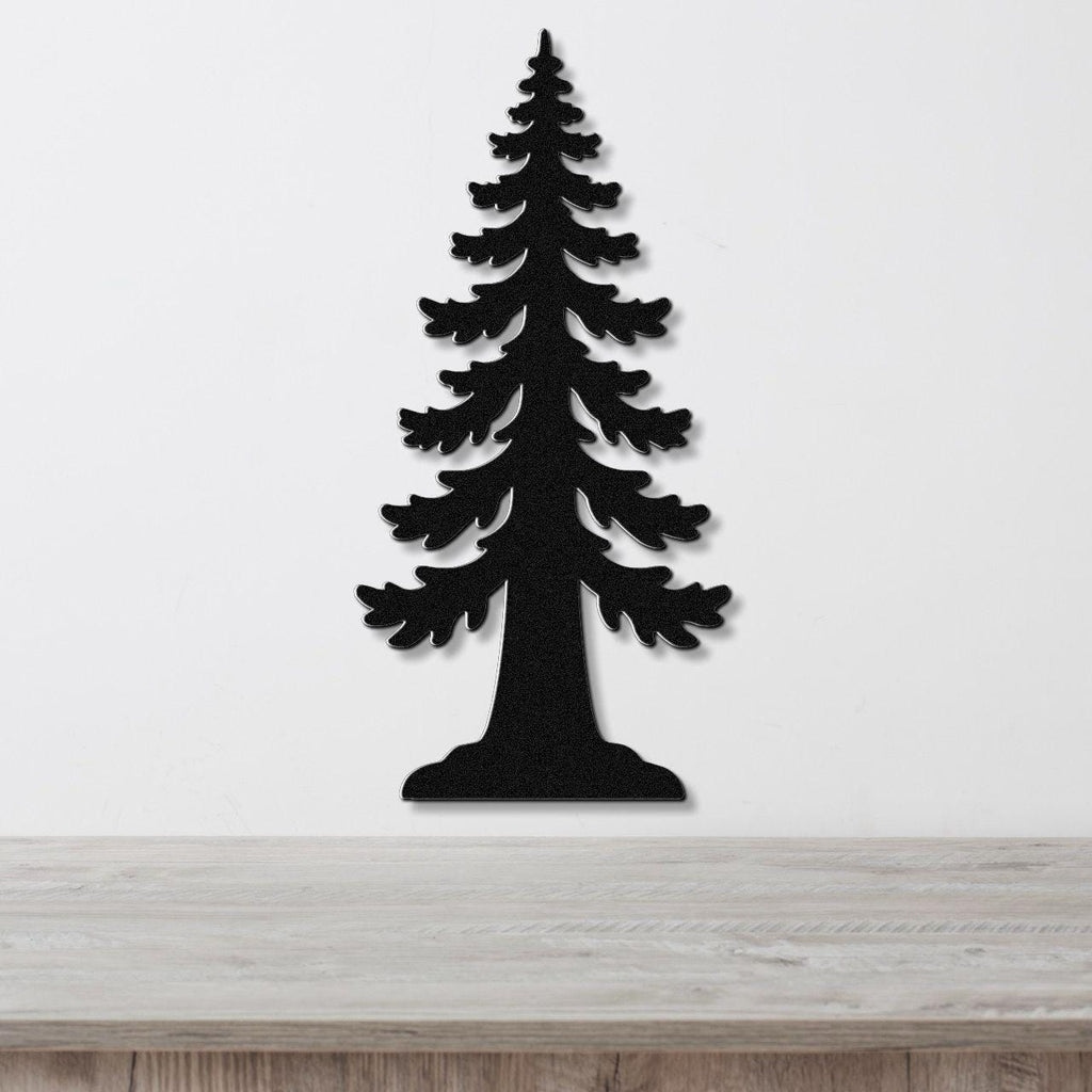 Black metal wall art in the silhouette of a sequoia tree with layered branch cutouts, mounted on a white wall above a light wood surface.