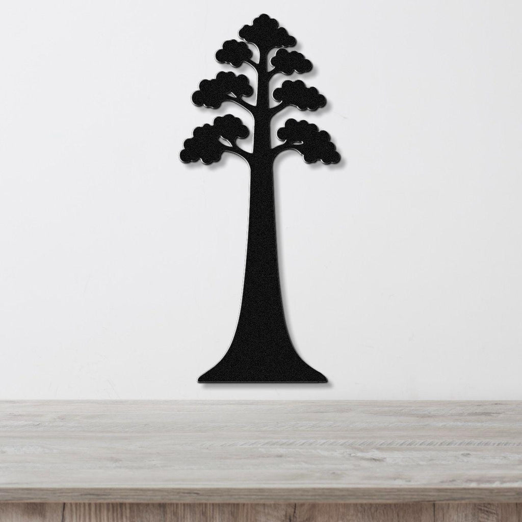 Black metal wall art in the silhouette of a sequoia tree with layered canopy cutouts, mounted on a white wall above a light wood surface.