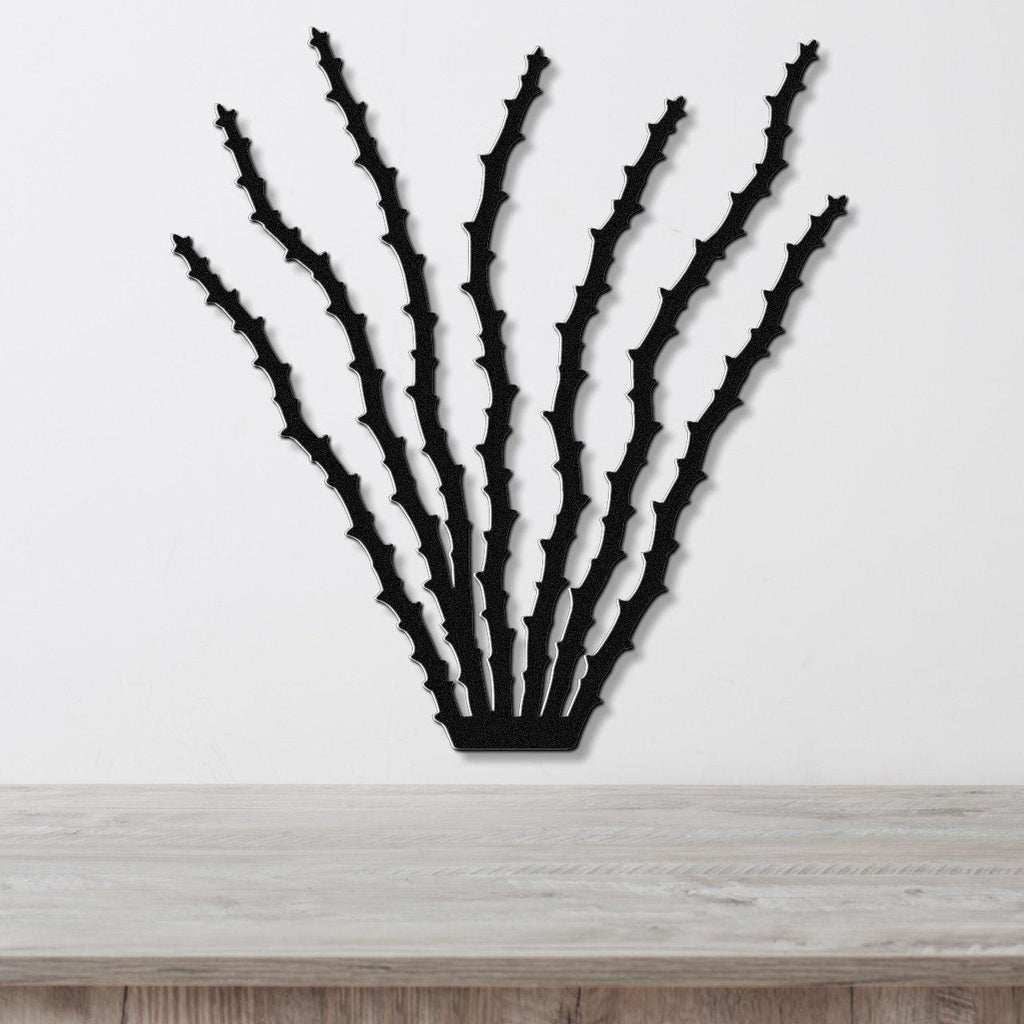 Black metal ocotillo wall art with spiky branch cutouts, mounted on a white wall above a light wood counter.