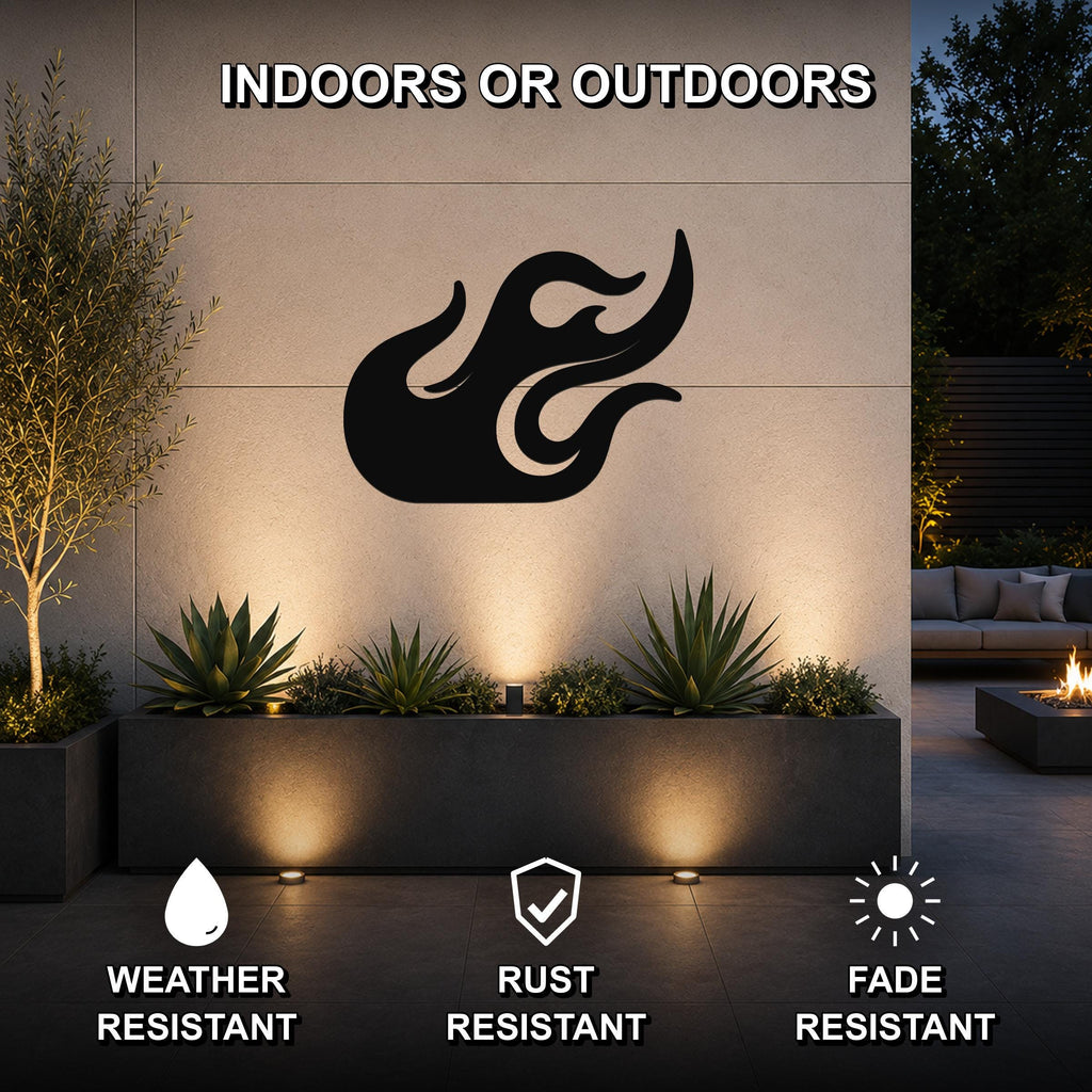 Black metal flame wall art with flowing cutout design, mounted on an outdoor wall above a planter in a modern patio setting.