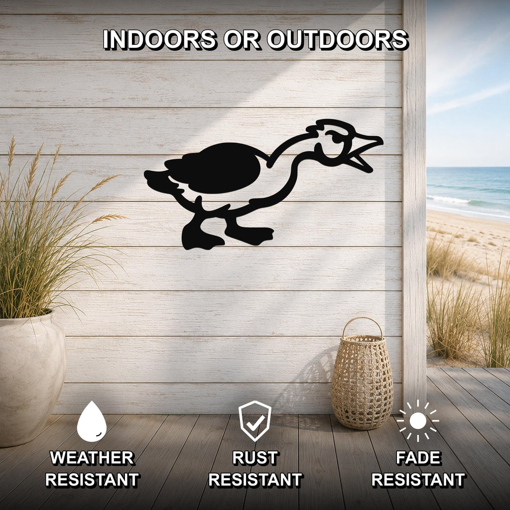 Black metal goose wall art silhouette mounted on a light wood plank wall, displayed on a patio with a beach view, weather resistant, rust resistant, and fade resistant.