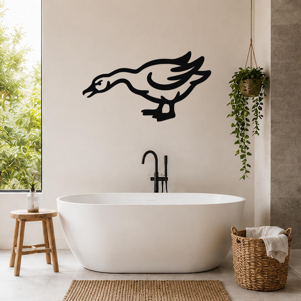 Black metal goose wall art with motion-line cutouts, mounted on a bathroom wall above a freestanding tub.