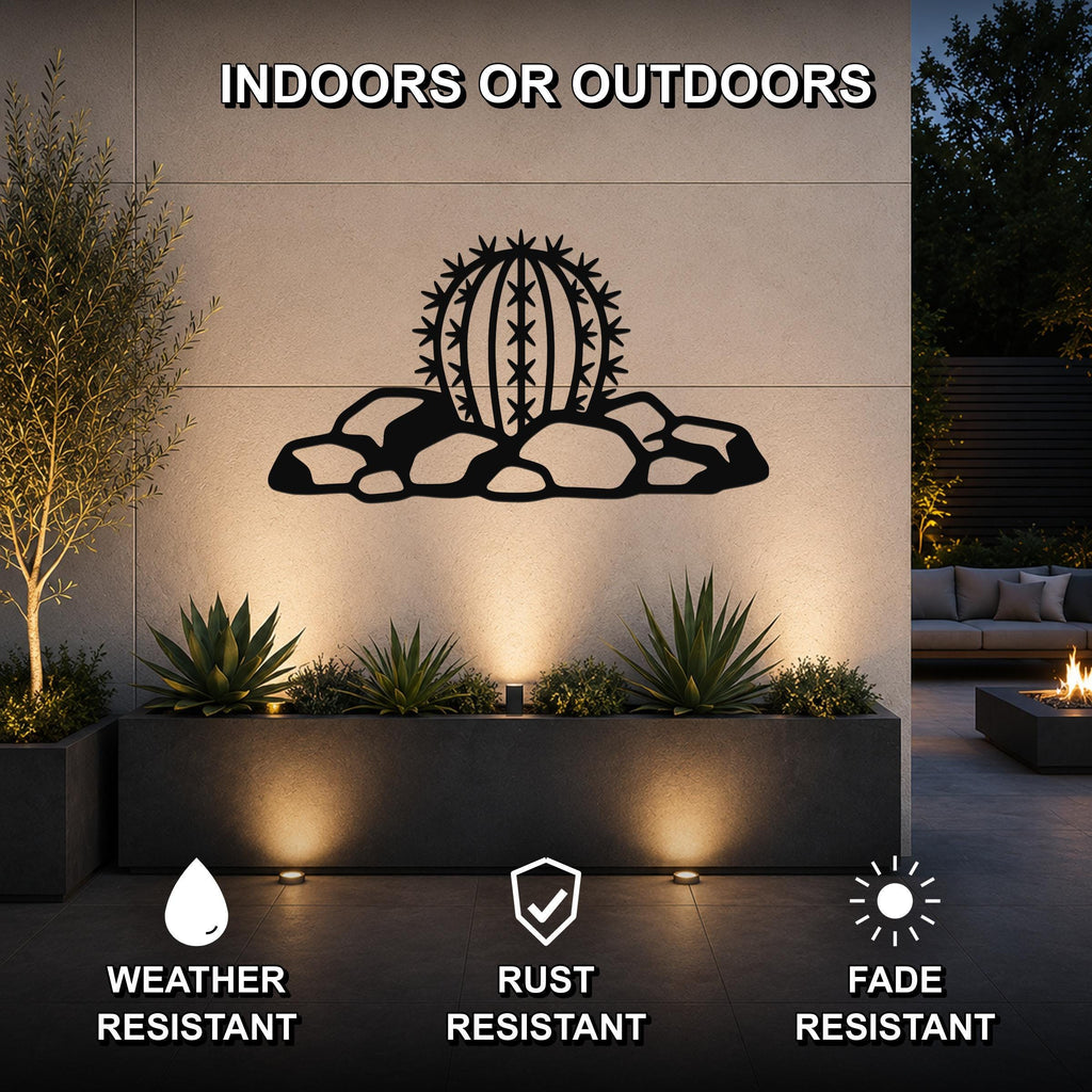 Black metal barrel cactus wall art with spines and rocks cutout, mounted on an outdoor wall above a planter in a patio setting.