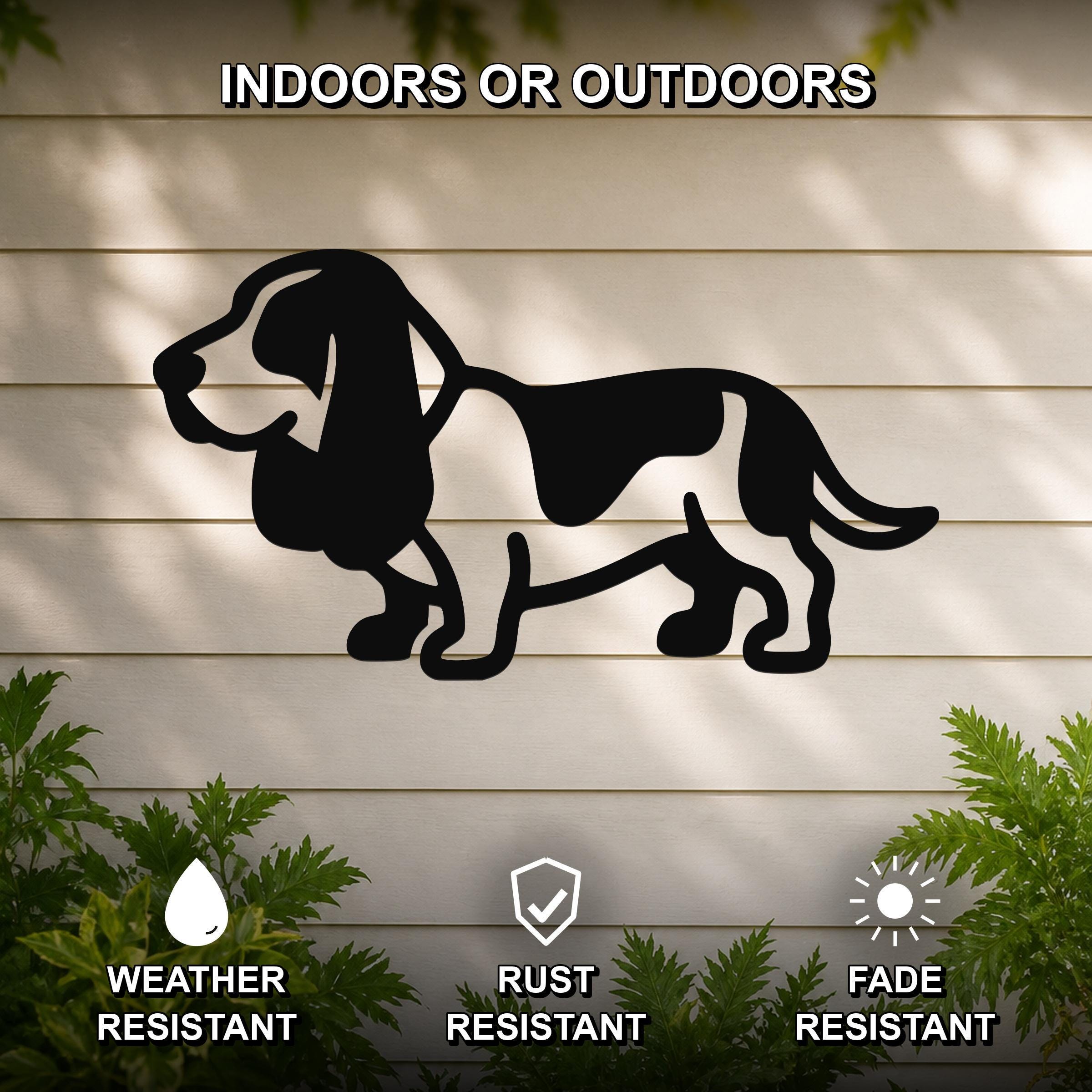 Black metal Basset Hound silhouette wall art mounted on a light-colored outdoor wall, with green plants at the base and text indicating it is weather, rust, and fade resistant.