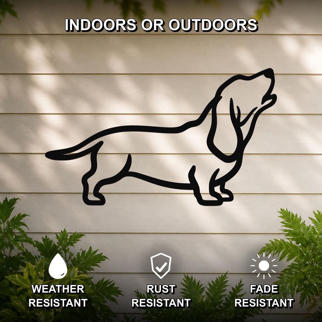 Black metal Basset Hound silhouette wall art mounted on a light-colored outdoor wall, with green plants at the base and text indicating it is weather, rust, and fade resistant.