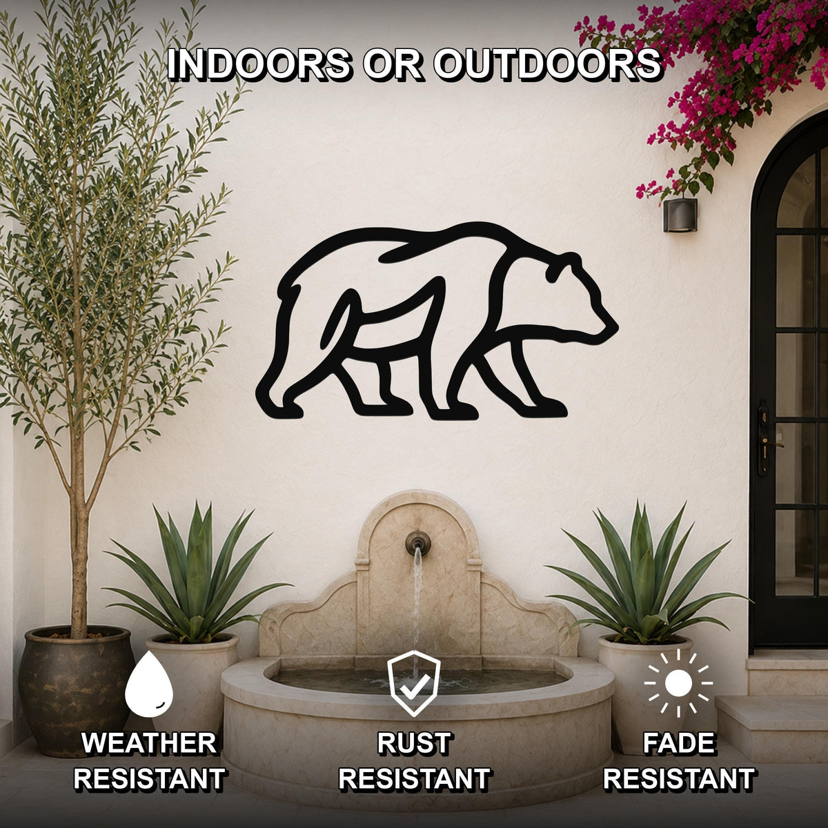 Black metal bear silhouette wall art mounted on an outdoor wall above a stone fountain, flanked by potted plants and a flowering vine.