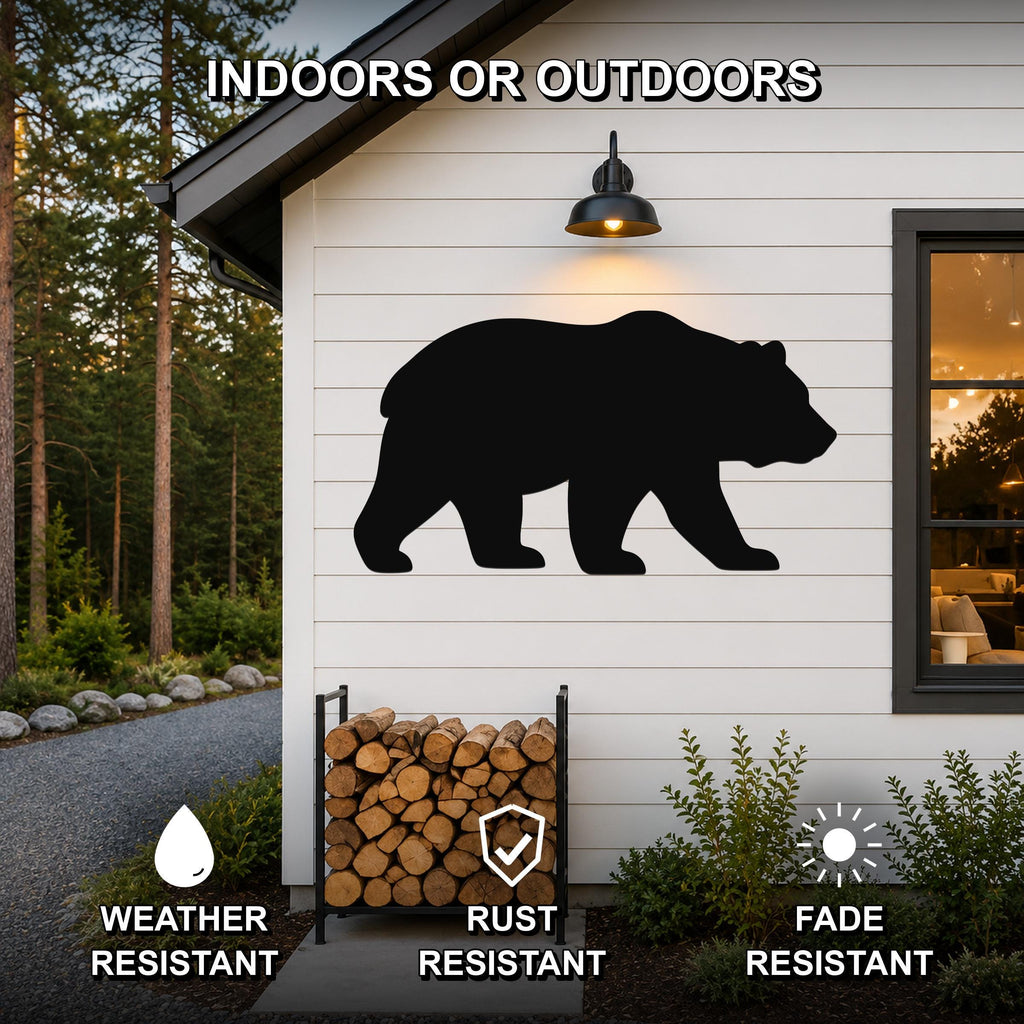 Black metal bear silhouette wall art mounted on a white siding exterior wall above a firewood rack, with text indicating it is weather, rust, and fade resistant for indoor or outdoor use.