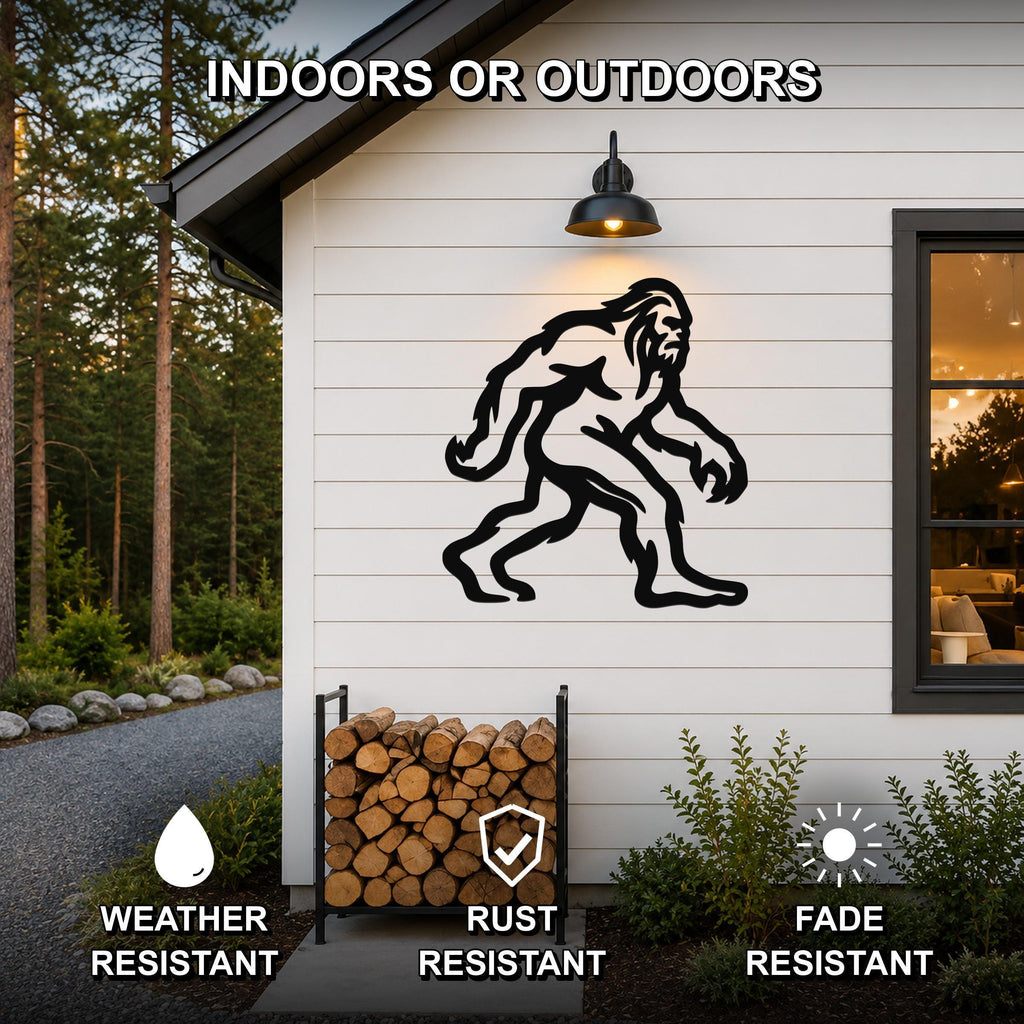 Black metal Bigfoot silhouette wall art mounted on a white siding exterior wall above a firewood rack, with text indicating it is weather, rust, and fade resistant for indoor or outdoor use.