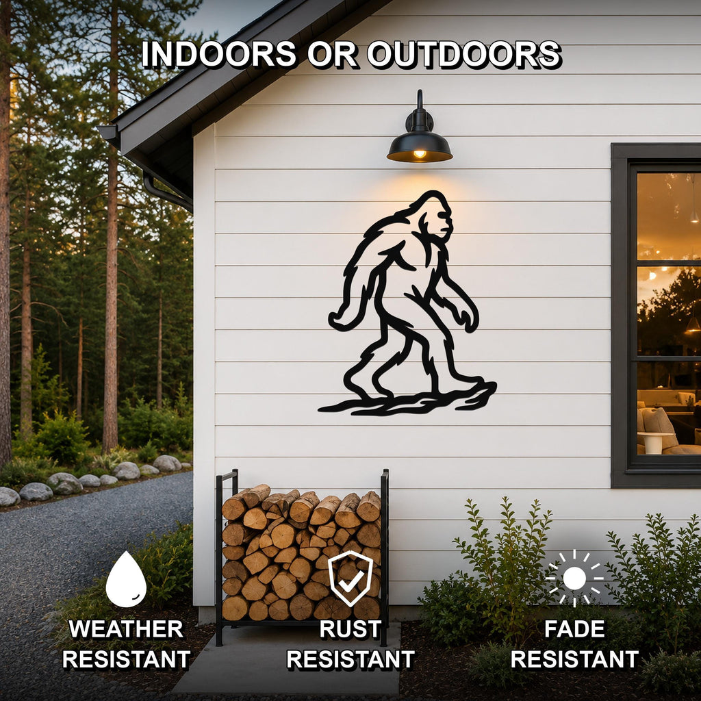 Black metal Bigfoot silhouette wall art mounted on a white siding exterior wall above a firewood rack, with text indicating it is weather, rust, and fade resistant for indoor or outdoor use.
